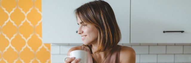 White woman with short brown hair looked to the left while holding a mug with the title text: 20 Things You Can Do to Distract Yourself From Coronavirus News