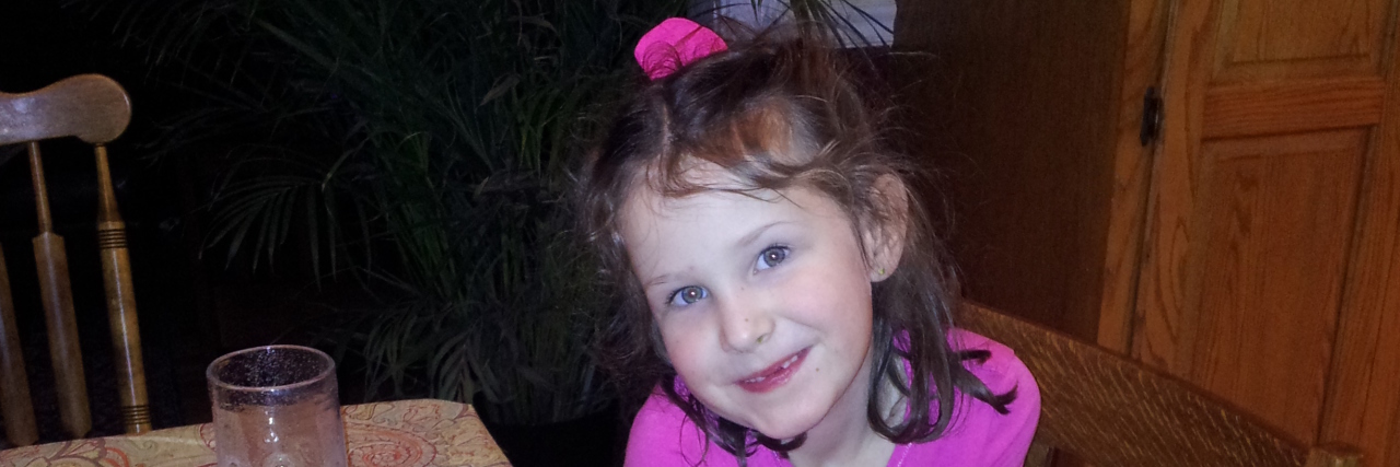 Processing Time and Emotions After Your Child's Death the author's daughter, smiling in front of her birthday cake at home.