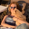 Van life with chronic illness -- Chelsea sitting outside her van, holding her orange cat.