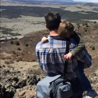 Parent holding child in the desert.