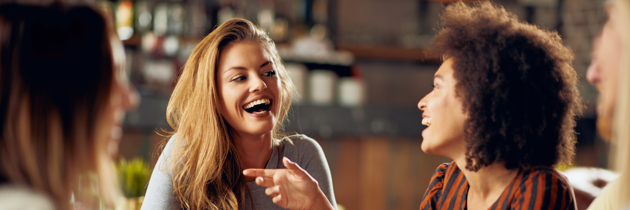 Using Humor as a Coping Strategy in Life With a Health Condition Friends laughing in a restaurant.
