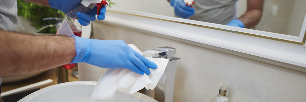 How Long Does COVID-19 Live on Surfaces? Man's hands cleaning sink in the bathroom