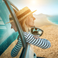 Woman traveling with fibromyalgia, looking out the window at the ocean.