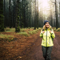 woman in the middle of a hiking trail smiling