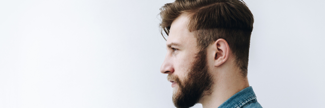 Profile of a man with a beard looking forward