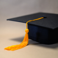 Black Graduation Hat placed on brown paper