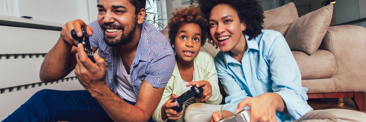How Gaming Can Strengthen Family Bonds During the Coronavirus Pandemic Family sitting on the couch together playing video games.