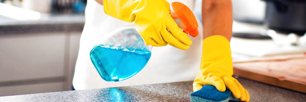 What It's Like to Be Manic While in COVID-19 Quarantine Woman Using Spray Polish To Clean Kitchen Surface