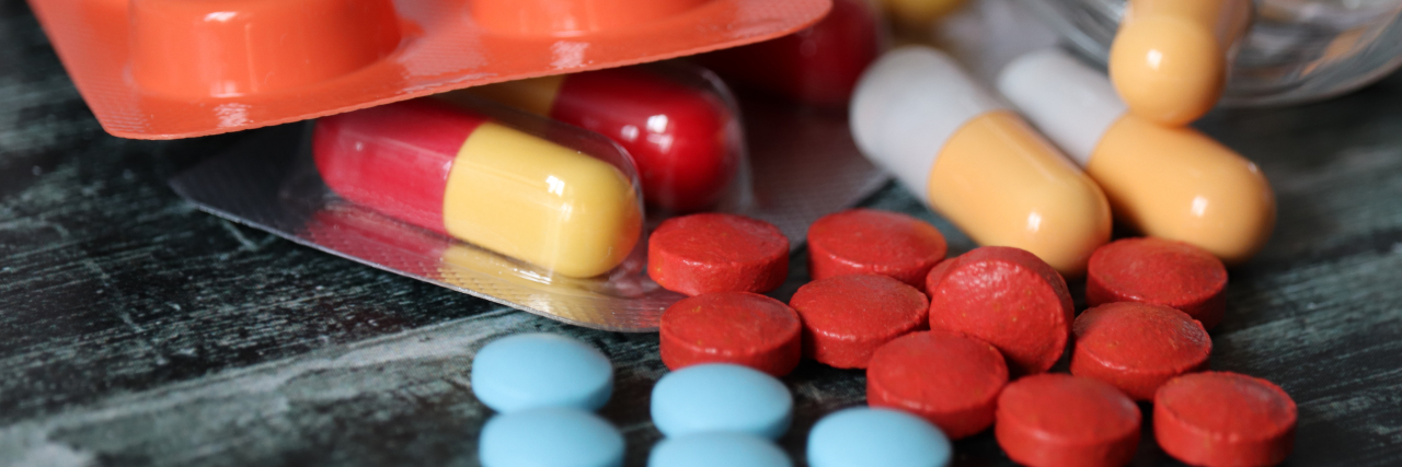 Why I'm Skeptical About New Chronic Pain Treatments Pills and capsules on table.