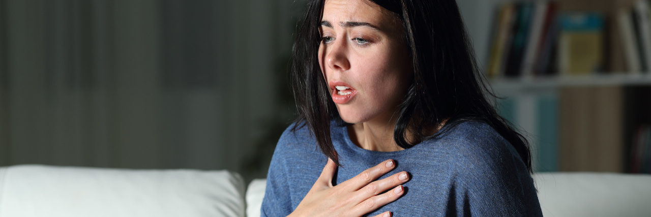 Differences Between Anxiety and COVID-19 Symptoms Woman suffering an anxiety attack alone in the night