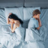 Couple in bed facing away from each other