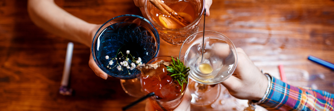 To the People Still Going Out 'For Fun' Despite the COVID-19 Outbreak friends clinking by glasses with various alcoholic cocktails at table,close up top view