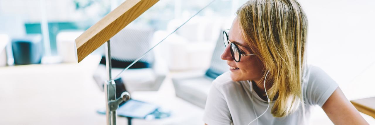 Combatting Boredom and Guilt From My Depression Woman with glasses listening to headphones