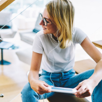 Woman with glasses listening to headphones