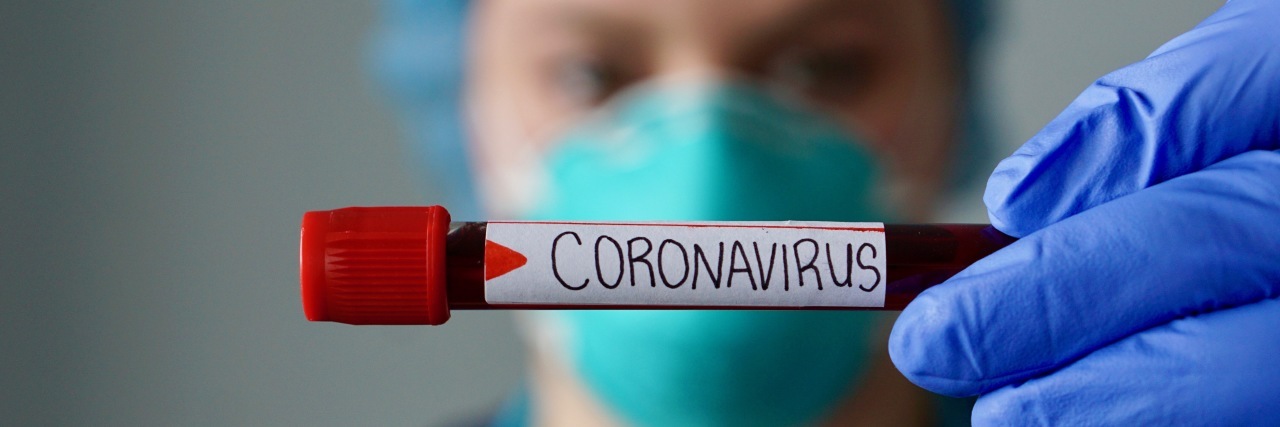 A View From the Front Lines of California’s COVID-19 Battle Nurse wearing respirator mask holding a positive blood test result for COVID-19.