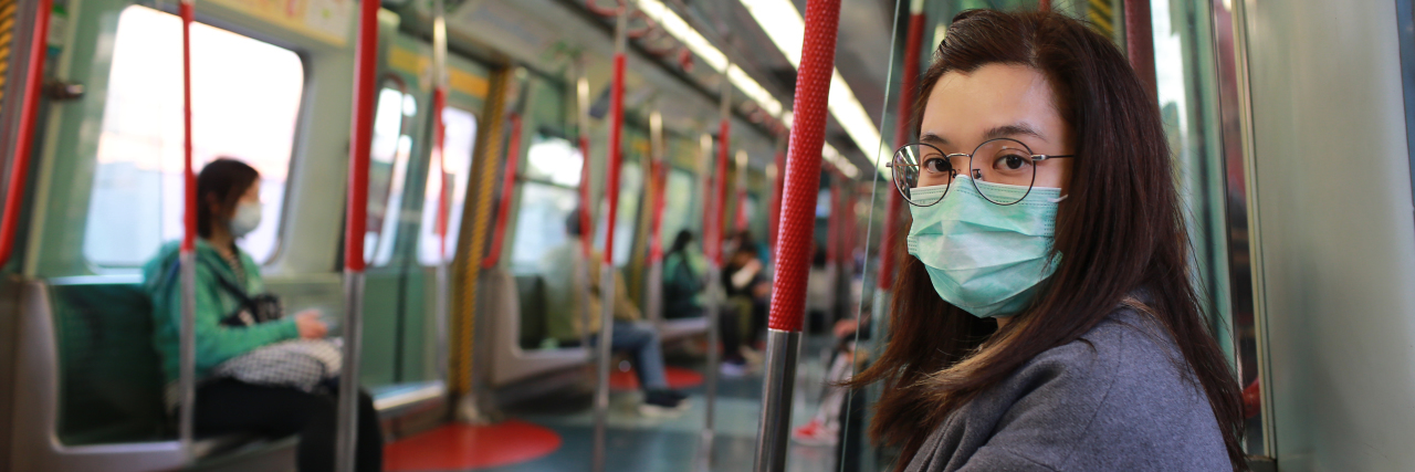 The Importance of Face Masks for Immune Suppressed People Girl wearing mask to protect herself from Wuhan coronavirus on train.