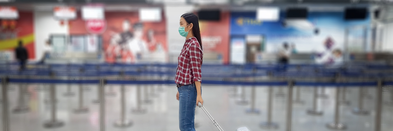 Asian tourist with luggage ,wearing mask to prevent during travel time at the airport terminal for protect from the new Coronavirus 2019 infection outbreak situation