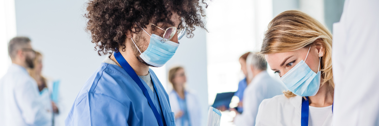 Sudden Loss of Smell or Taste May Be a COVID-19 Symptom A group of doctors talking about corona virus on conference.