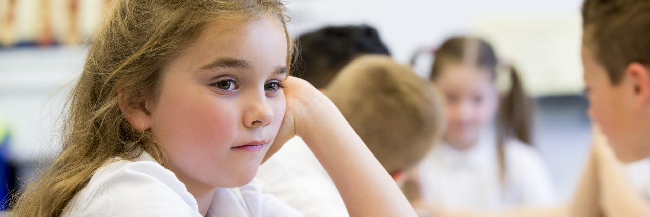 Growing Up With a Learning Disability Close up shot of a little girl at school who looks distant and upset.