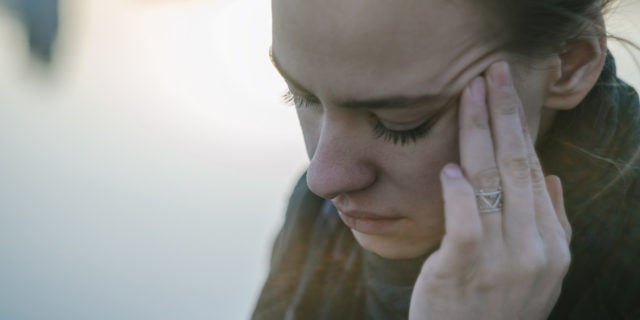 The Mental Illness That Makes It Hard for Me to 'Just Stop' Touching My Face A woman touching her temple