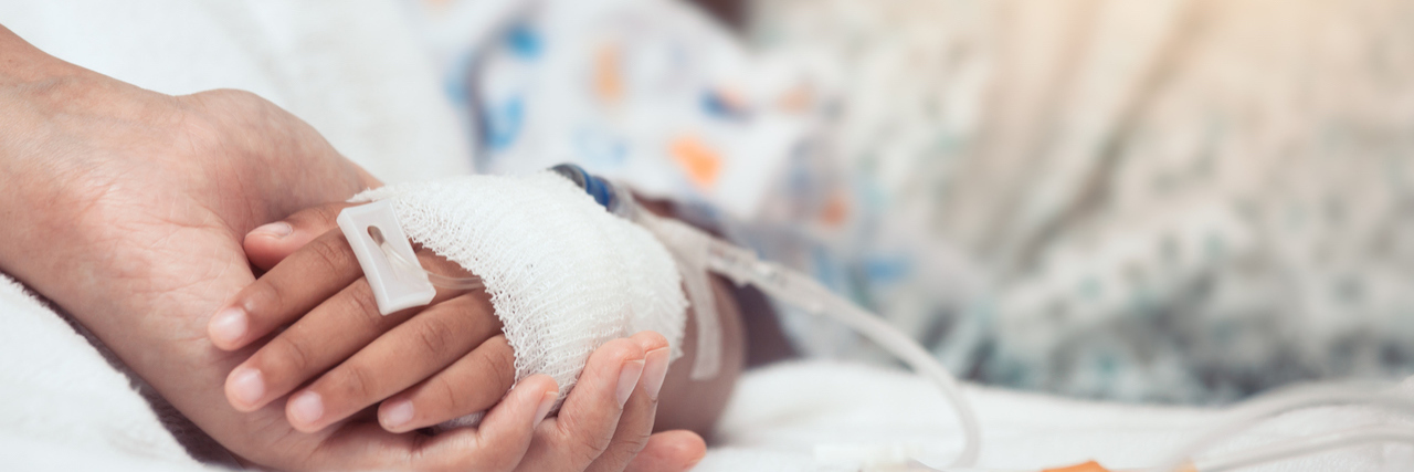 Accepting Sadness and Anger When Parenting a Child in the Hospital Parent holding the hand of a child in the hospital