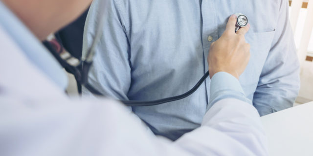 Close up of doctor listening to patient heartbeat with stethoscope on hospital, Physical examination, Medical and health care concept. (Close up of doctor listening to patient heartbeat with stethoscope on hospital, Physical examination, Medical and h