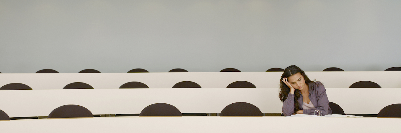 A woman sitting alone in a lecture hall