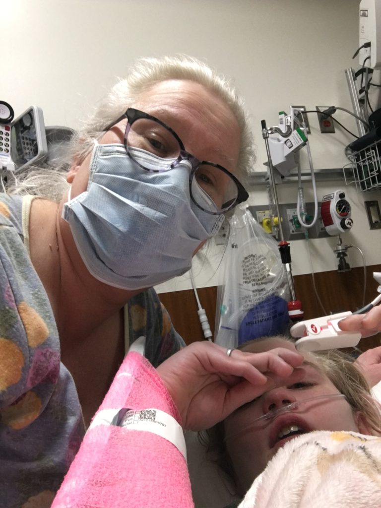 photo from contributor showing her lying in hospital with blonde woman wearing glasses and hospital mask nearby