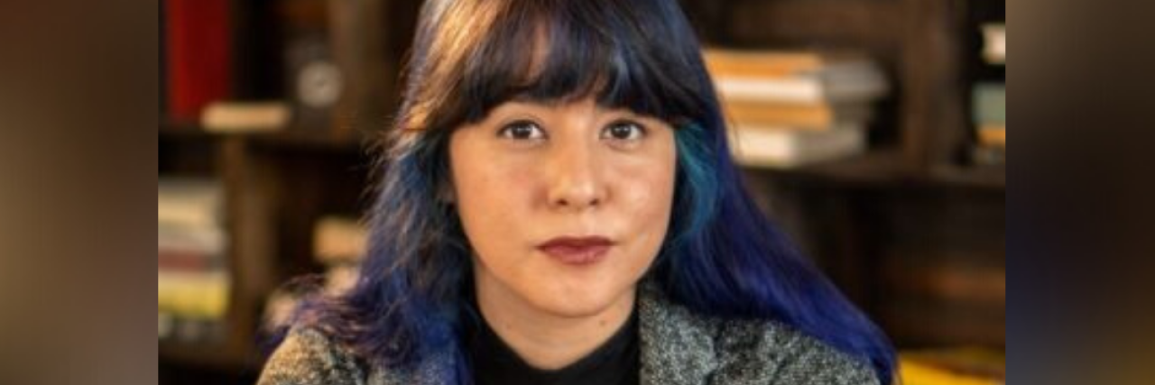 How a Writing Assignment in School Helped Me Face My Anxiety Head-On photo of author's book cover: author sitting at a table in front of a bookcase