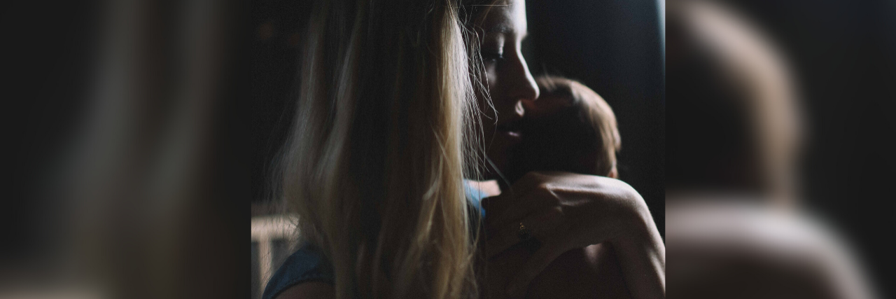 Help for Postpartum Depression During the Coronavirus Outbreak photo of woman in darkness holding baby