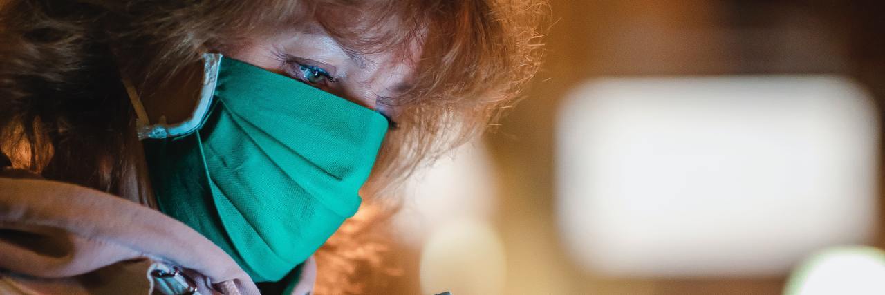 What to Know If You're Struggling as a NICU Parent During COVID-19 photo of woman in illness mask looking at phone