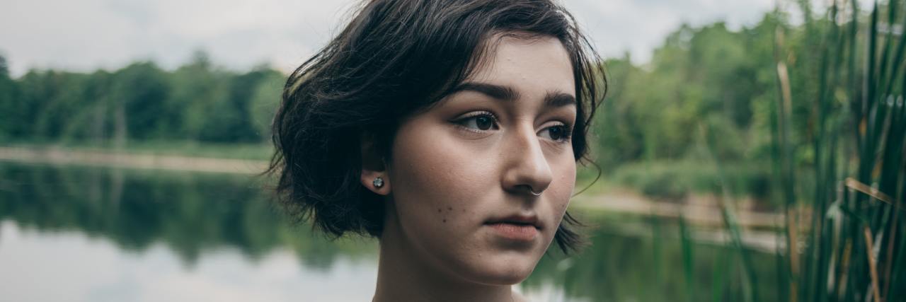 How the Coronavirus Is Affecting People With Trauma and PTSD young woman in front of a lake looking in the distance