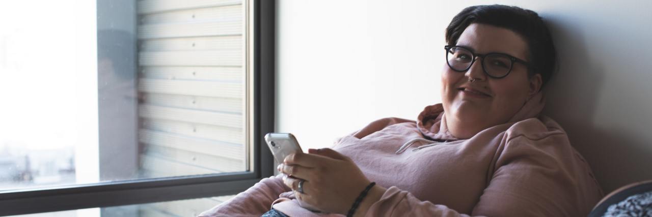 Why People With a Chronic Illness Need Our Smartphones Woman in bed using smartphone.