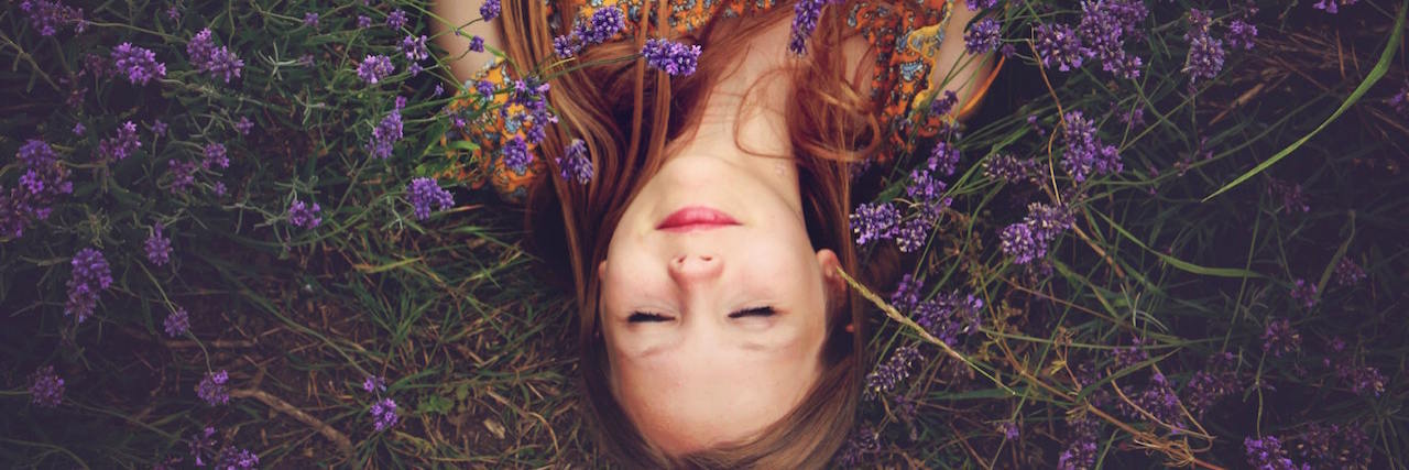 Missing the Person I Was Before Trauma Woman with her eyes closed surrounded by purple flowers