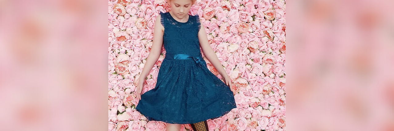 My Child Is More Than Just Her Disability Callie wearing a blue dress. Her prosthetic leg is visible.