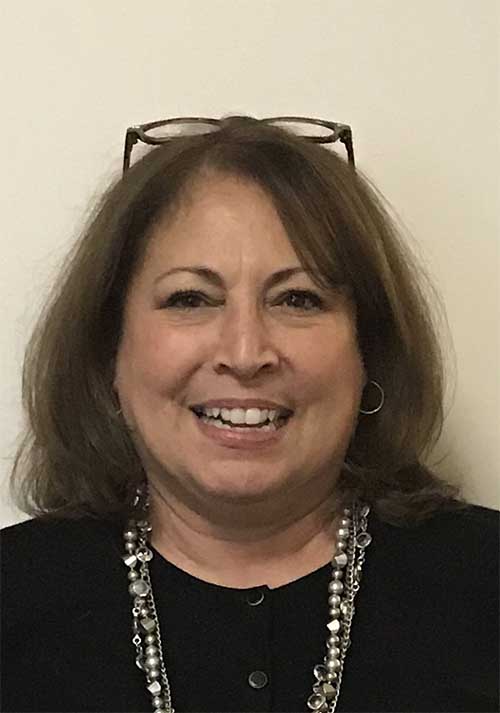 Cyndi wearing a black blouse and necklace.