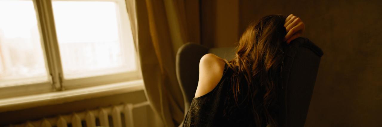 How Accomplishing What I Can With the Energy I Have Helps My Anxiety back of a woman stressed in black curled up in a chair