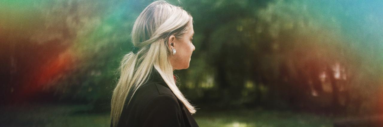 Quotes I'll Try to Remember When I'm Feeling Suicidal photo of young blonde woman standing in nature with trees behind her and a rainbow of light over her