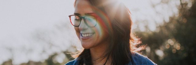 photo of woman looking happy with eyes closed and sunlight shining on her face in a lens flare