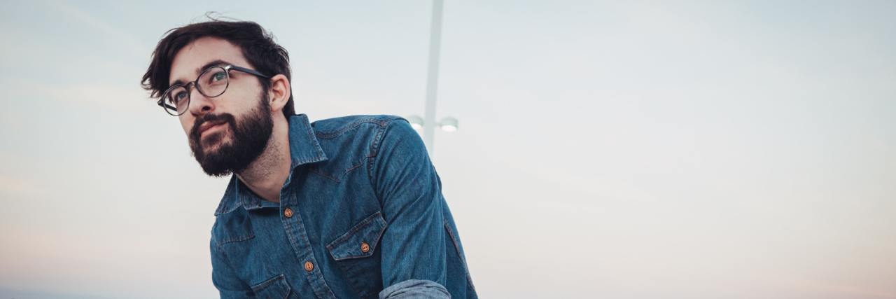 How I Found Out I Had Complex PTSD and Healed After Years of Abuse man with glasses in a denim shirt on a beach looking outward