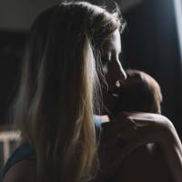 photo of woman in darkness holding baby