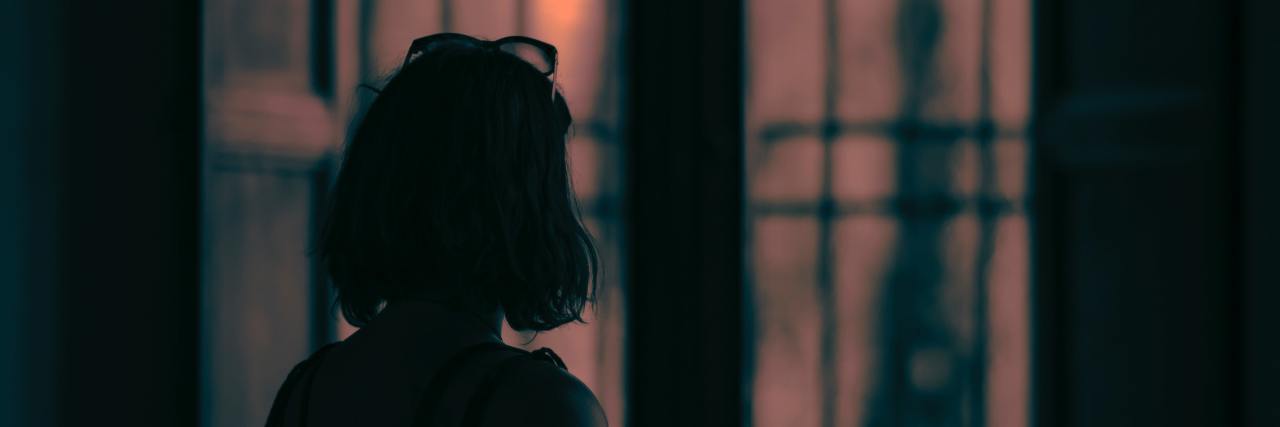 Coronavirus: When You're at Risk and Live in Washington State photo of woman silhouetted in front of window with orange light