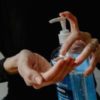 photo of woman cleaning hands with hand sanitizer