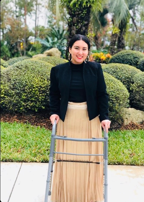 Kimberly standing outside with her walker.