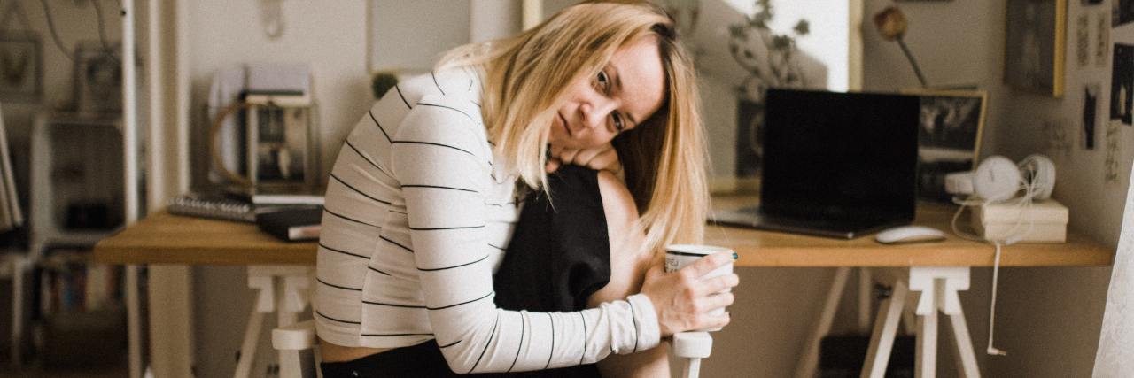 What People With Chronic Illness Think About COVID-19 Woman sitting on a chair holding a cup of tea