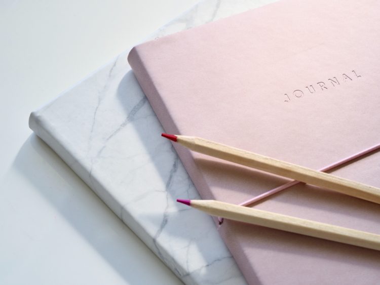 A pink journal on top of a white counter.