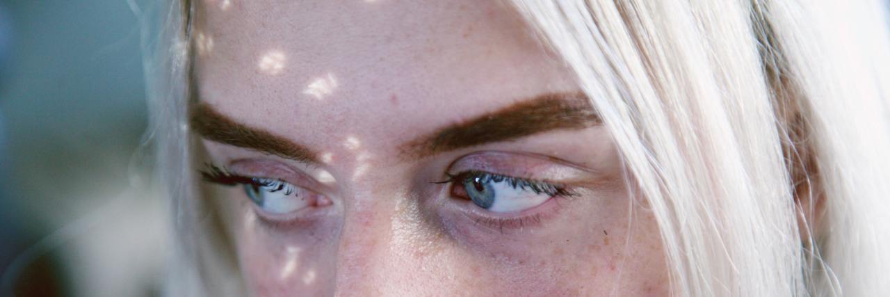 Challenging Parts of Living With Dissociative Identity Disorder A close up of a woman with blue eyes