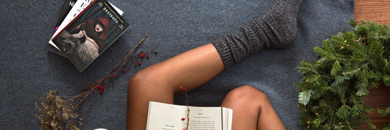 How My Aunt's Suicide Changed How I Saw the Socks She Gave Me woman sitting down, wearing thick socks, reading a book