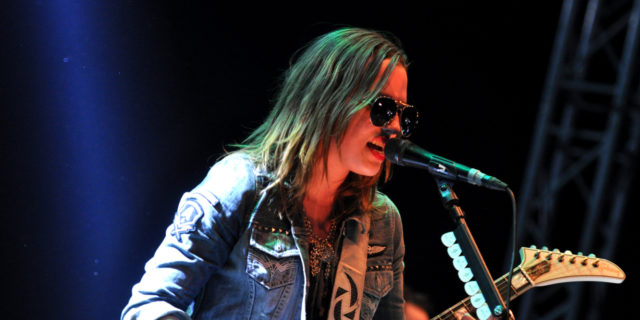 Lzzy Hale performs onstage with her guitar.