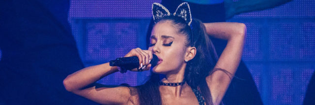 Ariana Grande performs onstage while wearing bunny ears